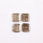 Four emerald-cut champagne lab grown diamonds with visible salt and pepper style inclusions, faceted step-cut stones in warm brown tones on white background