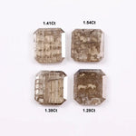 Four emerald-cut champagne lab grown diamonds with visible salt and pepper style inclusions, faceted step-cut stones in warm brown tones on white background
