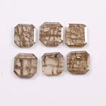 Six emerald cut octagonal lab grown diamonds featuring distinctive golden vein-like inclusions in a transparent champagne-toned base, displayed on a white background.