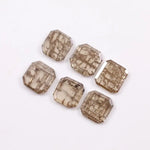 Six emerald cut octagonal lab grown diamonds featuring distinctive golden vein-like inclusions in a transparent champagne-toned base, displayed on a white background.