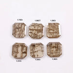 Six emerald cut octagonal lab grown diamonds featuring distinctive golden vein-like inclusions in a transparent champagne-toned base, displayed on a white background.