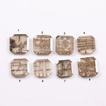 Eight emerald cut lab grown diamonds in champagne tones featuring visible natural-style inclusions and geometric internal patterns, arranged on a white background for fine jewelry selection.