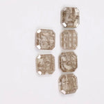 Six octagon step cut lab grown diamonds in fancy light champagne color with natural style inclusions, arranged on white background, ethically created loose stones for custom fine jewelry designs.