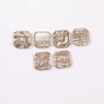 Six octagon step cut lab grown diamonds in fancy light champagne color with natural style inclusions, arranged on white background, ethically created loose stones for custom fine jewelry designs.