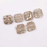 Six octagon step cut lab grown diamonds in fancy light champagne color with natural style inclusions, arranged on white background, ethically created loose stones for custom fine jewelry designs.