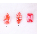 Three lab grown pink diamonds displayed on a white background, including a pear cut, marquise cut, and emerald cut fancy vivid pink loose diamonds for custom fine jewelry and engagement rings.