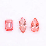Three lab grown pink diamonds displayed on a white background, including a pear cut, marquise cut, and emerald cut fancy vivid pink loose diamonds for custom fine jewelry and engagement rings.