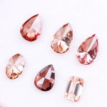 Six lab grown fancy colored diamonds in pink, blush, champagne and deep rose tones featuring pear, oval and emerald cuts displayed on a white background for fine jewelry design.