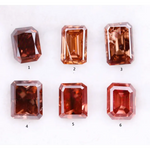 Six lab grown fancy orange pink emerald cut diamonds displayed on a white background, rectangular step cut loose grown diamonds in various reddish peach shades for engagement rings and fine jewelry.