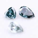 Three blue lab grown diamonds displayed on white background: pear cut light blue diamond (1), heart cut teal diamond (2), and deep blue pear shaped diamond (3), brilliant faceted loose stones for engagement ring or custom fine jewelry.