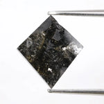 sharp kite cut rustic black diamond gemstone showcasing brilliant, highly reflective facets across a sleek triangular silhouette.