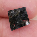 sharp kite cut rustic black diamond gemstone showcasing brilliant, highly reflective facets across a sleek triangular silhouette.