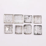 Square step-cut lab grown diamond with beveled edges and geometric faceting, loose ethical man made diamond for engagement ring or custom fine jewelry setting displayed on white background.