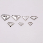 Seven clear lab grown diamonds in geometric faceted cuts arranged on white background, showing natural-style inclusions and transparent brilliance for jewelry making.