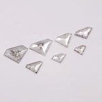 Seven clear lab grown diamonds in geometric faceted cuts arranged on white background, showing natural-style inclusions and transparent brilliance for jewelry making.