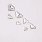 Seven clear lab grown diamonds in geometric faceted cuts arranged on white background, showing natural-style inclusions and transparent brilliance for jewelry making.