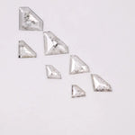 Seven clear lab grown diamonds in geometric faceted cuts arranged on white background, showing natural-style inclusions and transparent brilliance for jewelry making.