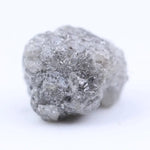 Close-up of rough diamond emphasizing natural sparkle and irregular, uncut crystal surfaces.