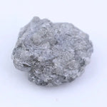 Natural black raw diamond embedded in rock with rough crystal structure and natural mineral texture