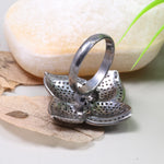 Vintage 4 Petal Pave wedding ring with emerald accents in an Art Deco sterling silver setting.