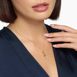 0.18 Ct with gold necklace featuring green gemstone pendant.