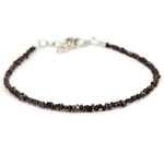 Close-up of a rough diamond bracelet with natural raw diamonds on a minimalist setting.