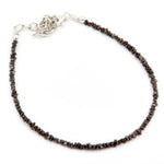 Close-up of a rough diamond bracelet with natural raw diamonds on a minimalist setting.