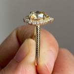 pear cut yellow diamond ring with round diamond halo