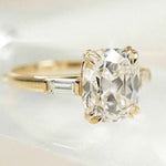 cushion cut diamond ring with baguette side stones in yellow gold