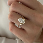 2 carat oval diamond three-stone ring set in white gold on a woman’s hand