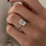 3 carat oval diamond three-stone ring set in polished white gold on a woman’s hand