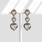Heart-shaped diamond earrings on a white background