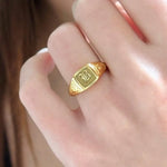 Elegant dainty gold initial ring with custom alphabet engraving in a sleek and stylish signet design