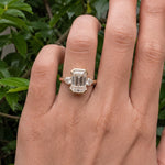 3 stone emerald engagement ring with elegant diamond setting