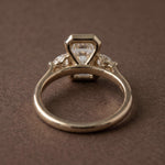 3 stone emerald engagement ring with elegant diamond setting