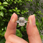 3 stone emerald engagement ring with elegant diamond setting