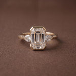 3 stone emerald engagement ring with elegant diamond setting