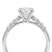 A silver-toned diamond engagement ring featuring a heart-shaped center stone in a prong setting, with small diamonds along the shoulders, shown on a plain white background.