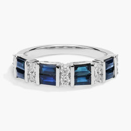 Close-up of 2.64 Ct lab created blue baguette cut gemstone ring with white accent stones on a polished metal band