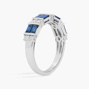 Close-up of 2.64 Ct lab created blue baguette cut gemstone ring with white accent stones on a polished metal band