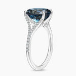 Luxury gemstone ring featuring vibrant colored stone with dazzling white stone halo des