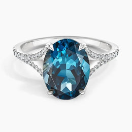 Luxury gemstone ring featuring vibrant colored stone with dazzling white stone halo des