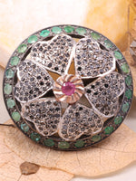 Decorative brooch with gemstones on a beige background with leaves