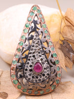 Decorative brooch with gemstones on a leafy background