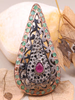 Decorative brooch with gemstones on a stone and leaf background