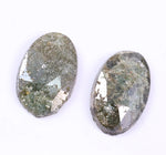 Two green oval stones on a white background