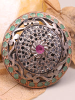 Decorative button with gemstones on a leafy background