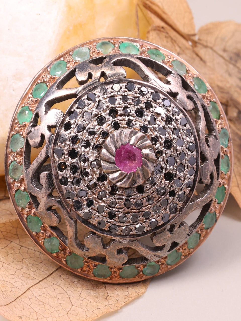 Decorative button with gemstones on a leafy background