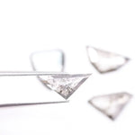 Four salt and pepper lab grown diamonds in shield, trillion, and geometric fancy cuts with natural grey inclusions, displayed on white background as loose ethical conflict-free stones for custom jewelry.