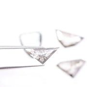 Four salt and pepper lab grown diamonds in shield, trillion, and geometric fancy cuts with natural grey inclusions, displayed on white background as loose ethical conflict-free stones for custom jewelry.